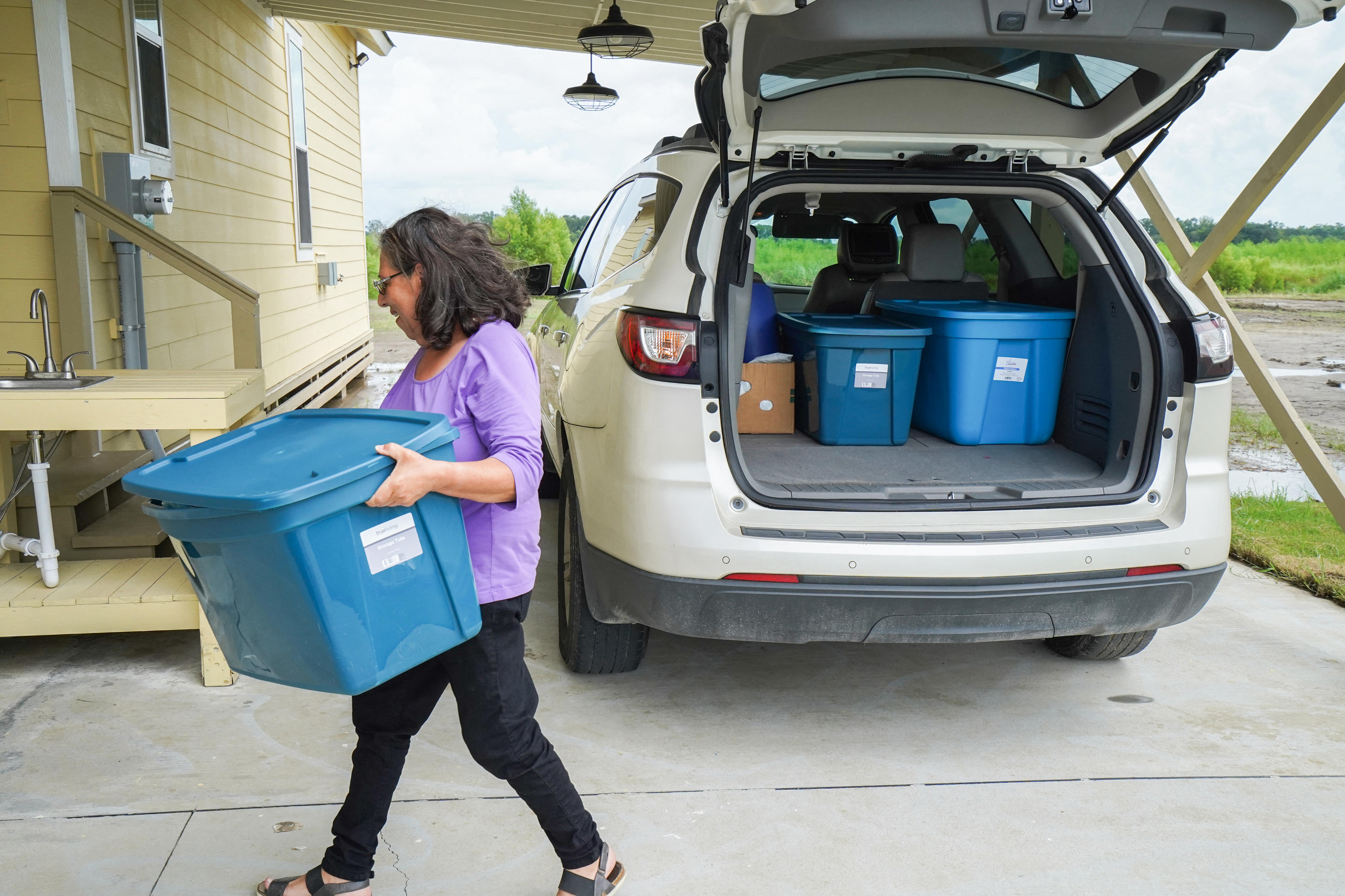 Joann Bourg carries her belongings into her new home