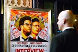 A security guard stands at the entrance of United Artists theatre during the premiere of the film "The Interview" in Los Angeles