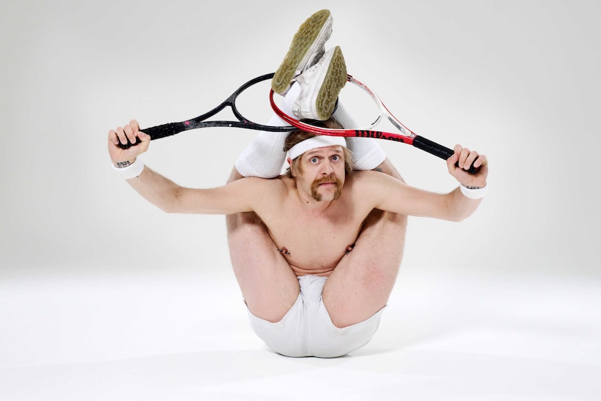 Contortionist posing with tennis rackets