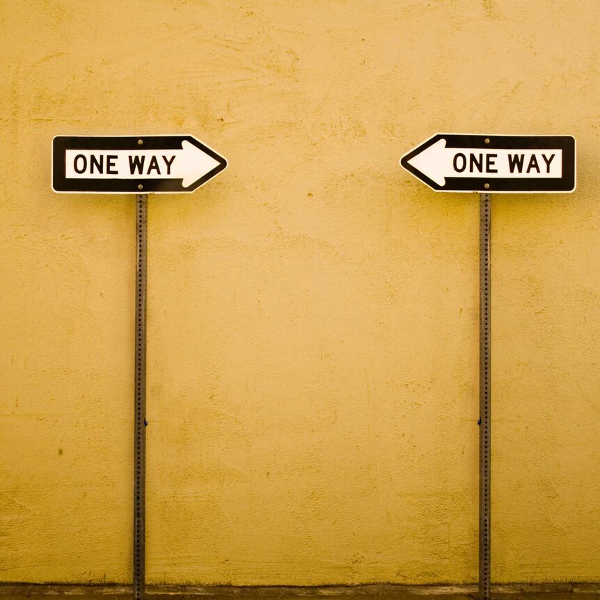 two "one way" signs pointing towards each other