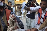 Medics carry an injured man on a stretcher after two suicide bomb attacks in Pakistan