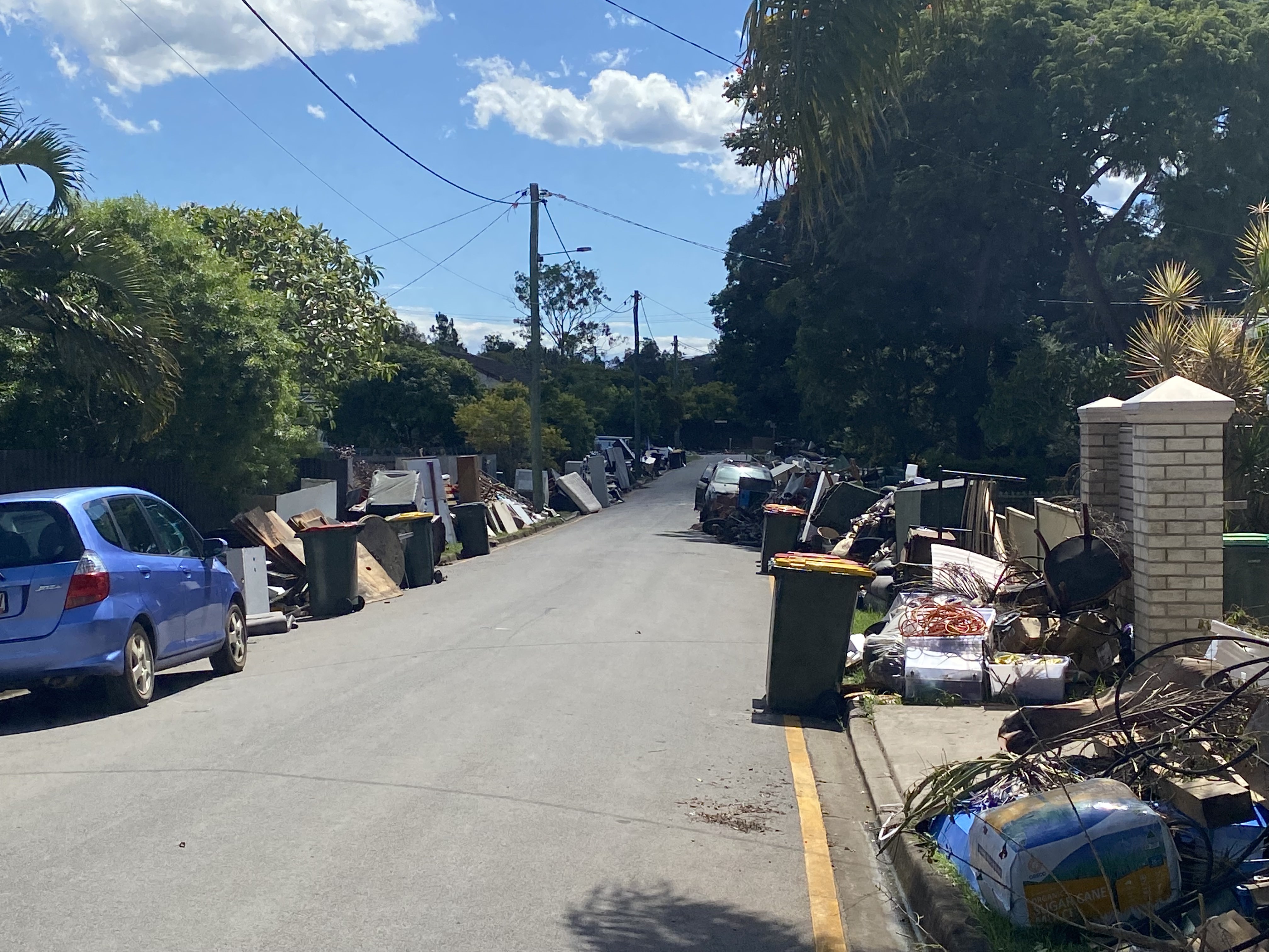 A suburban street with flood destroyed furniture and foods on both sides
