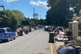 A suburban street with flood destroyed furniture and foods on both sides