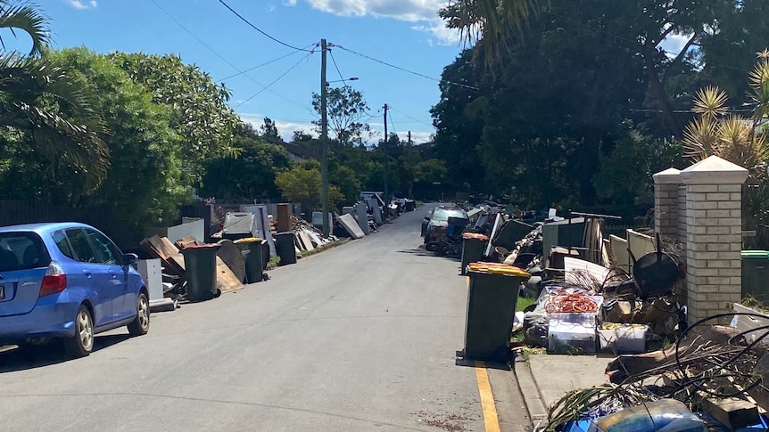 A suburban street with flood destroyed furniture and foods on both sides