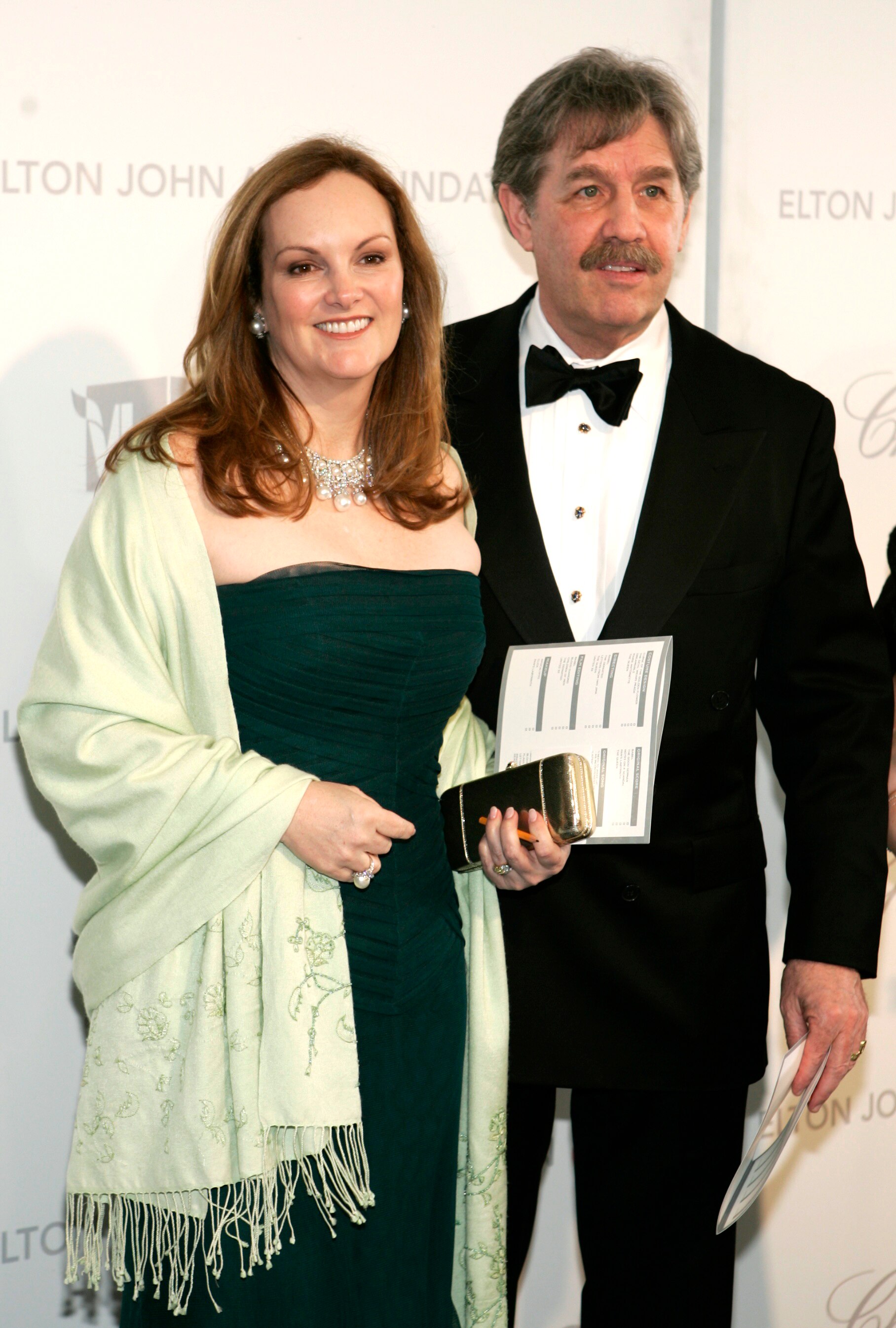 A woman in a strapless dress next to a man in a tux 