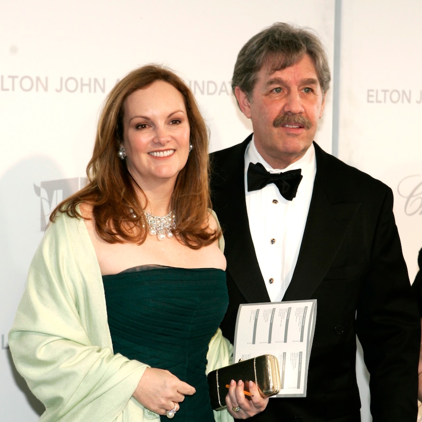 A woman in a strapless dress next to a man in a tux 