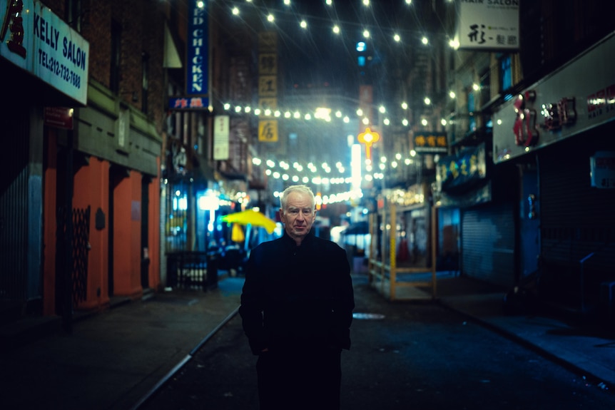 Still of modern-day John McEnroe walking through Chinatown in New York