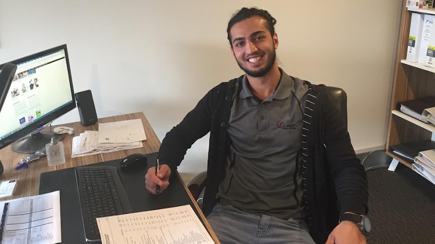 Tamim Nozhat sits at a desk.