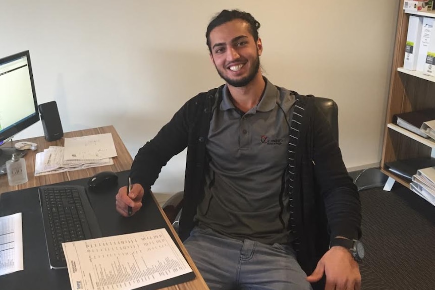 Tamim Nozhat sits at a desk.