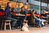 people sitting at tables outside a cafe