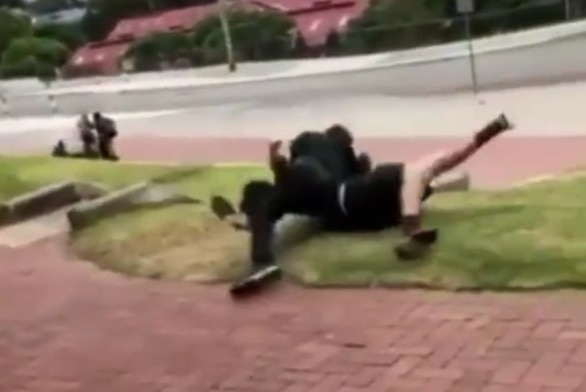 Two boys wrestle outside a school in one of the videos.