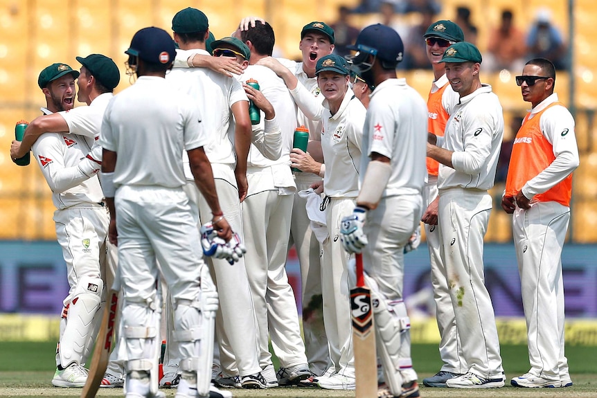 Australian players celebrate the dismissal of Virat Kohli during the third day of the second Test in Bangalore in 2017.