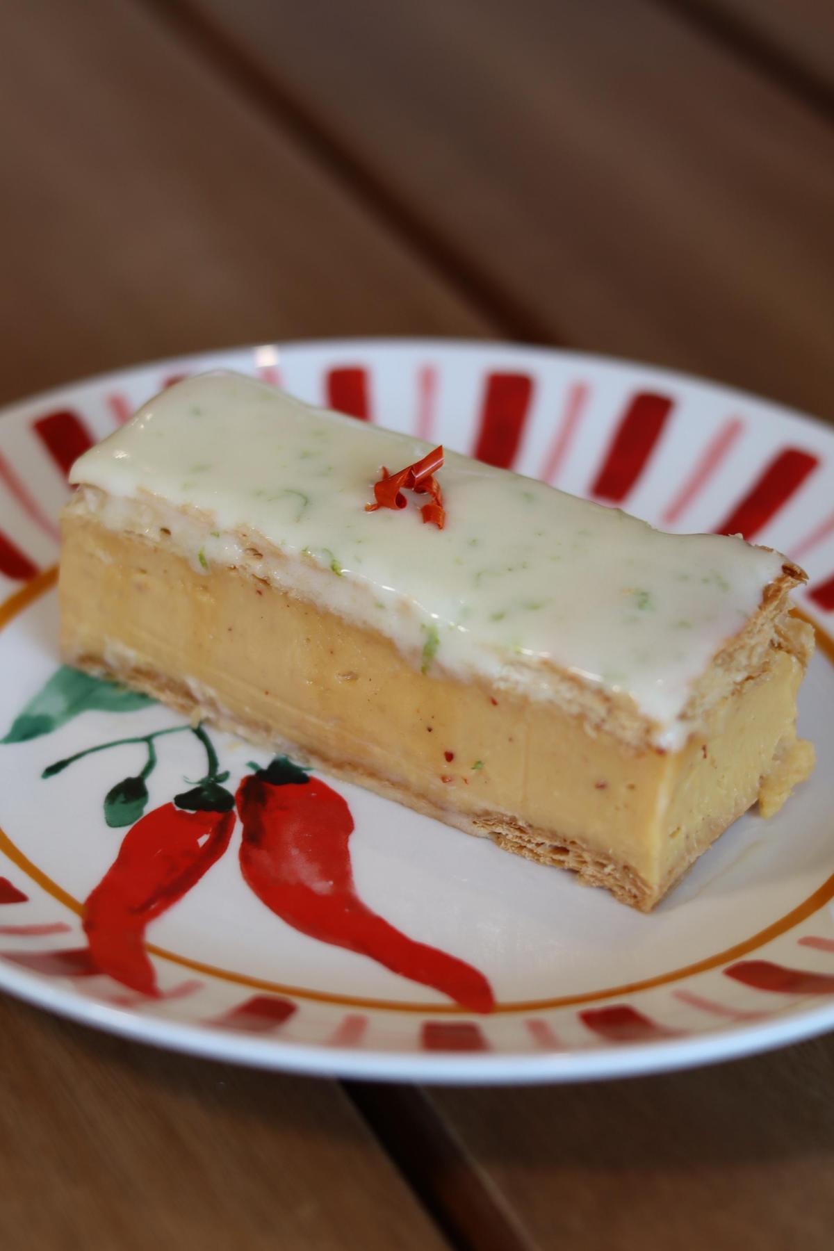 A vanilla slice with green flecks in the icing and chili on top.
