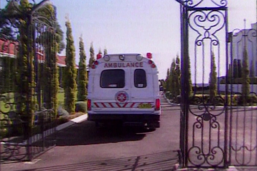 An ambulance pictures through wought iron gates