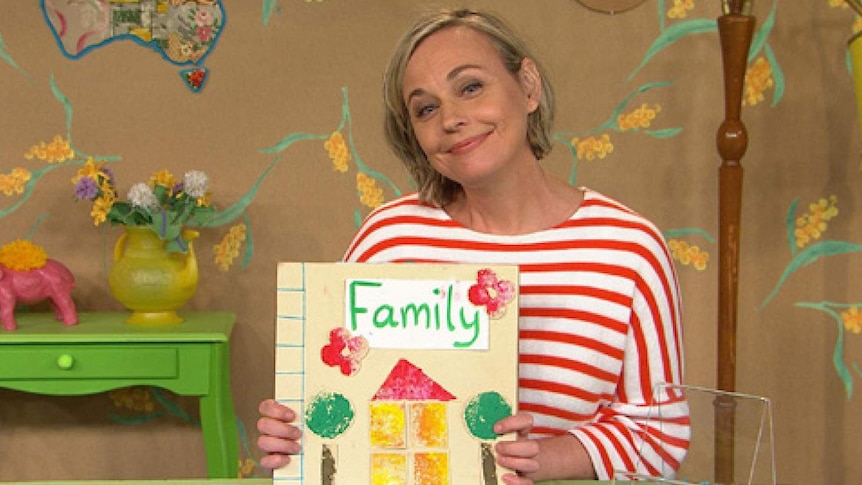 Abi holding up a book with the word "family" on the front