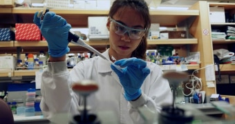 A scientist putting medication into a vial in a laboratory.