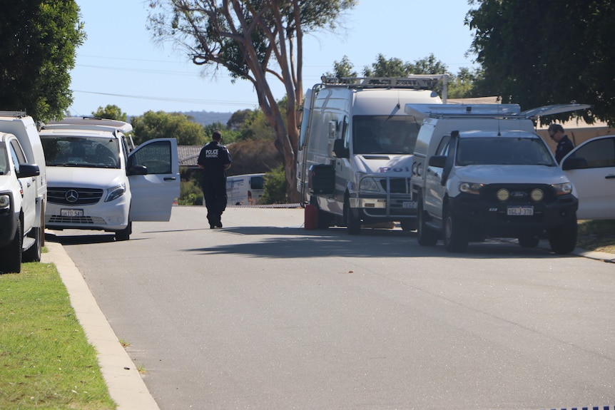 A police officer walks between two police vehicles.