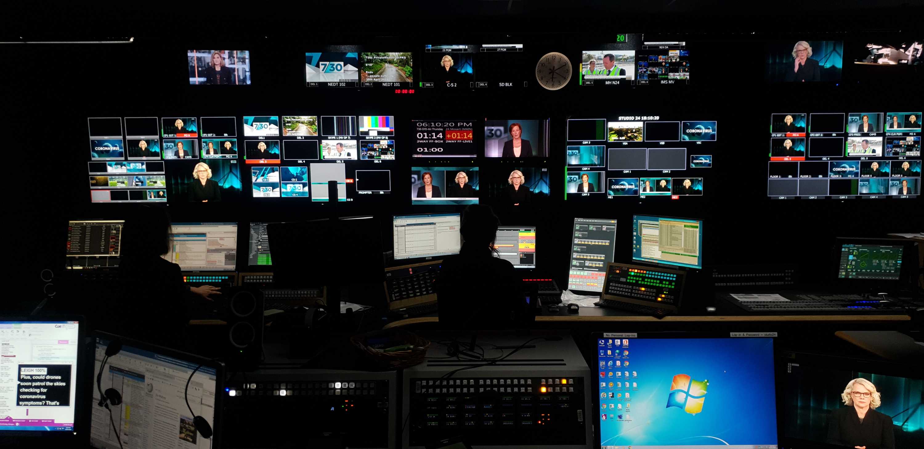 Wide shot inside studio control room with multiple TV monitors showing Leigh Sales and Laura Tingle on screen.