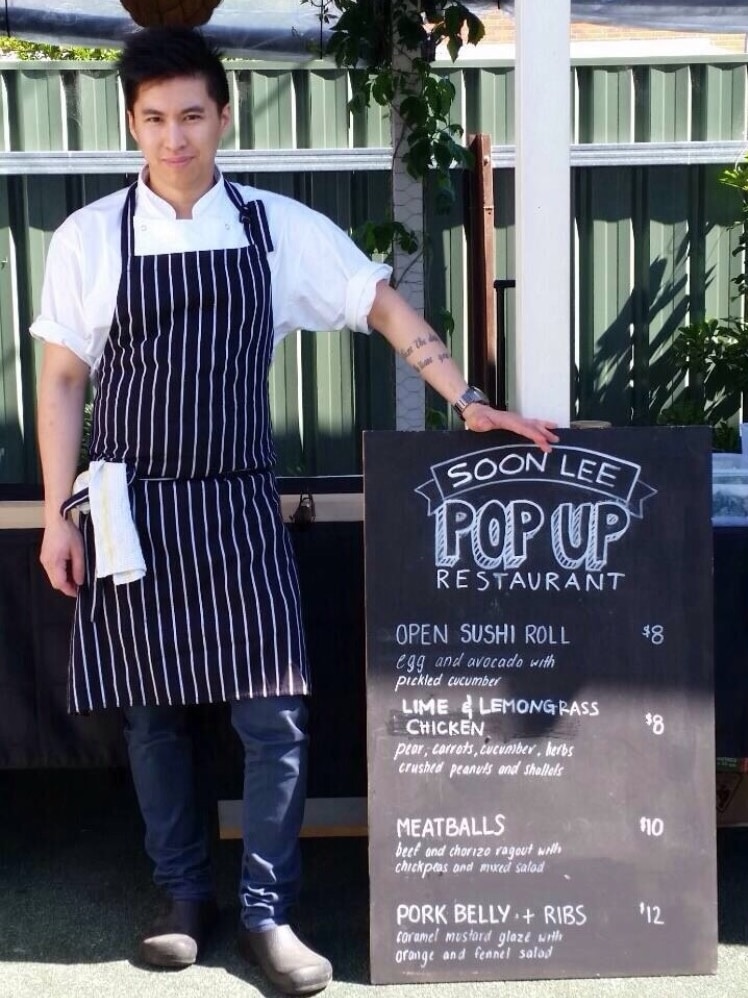 Soon Lee standing next to a menu sign at his pop-up in Wagga Wagga, a successful small business in regional Australia.