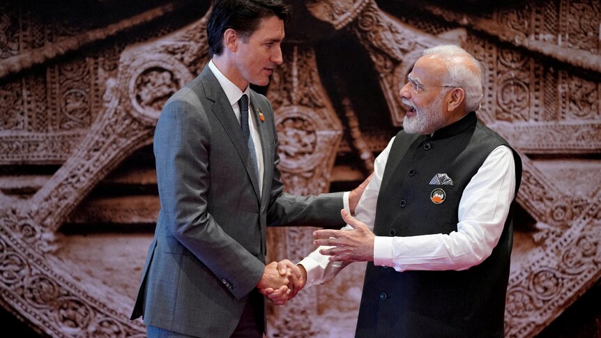 Justin Trudeau and Narendra Modi shaking hands. 