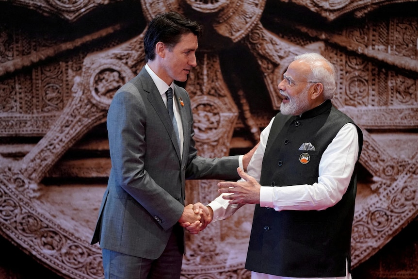 Justin Trudeau and Narendra Modi shaking hands. 