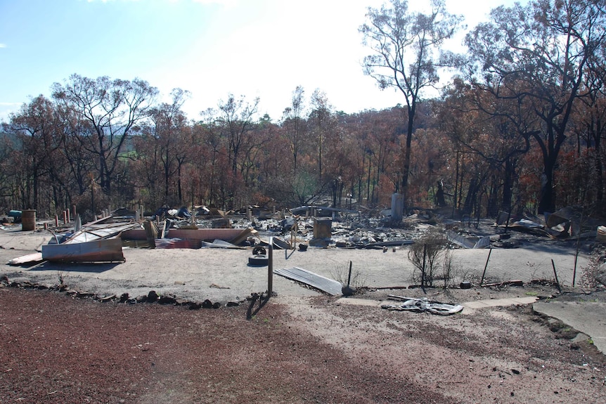 Remnants of a burnt out property consisting of sheet metal and brick after a fire