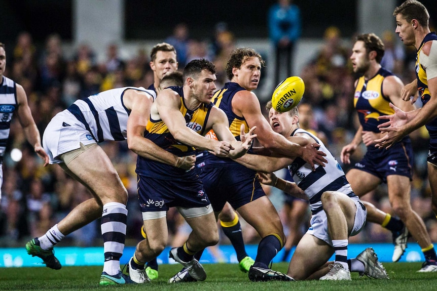 Luke Shuey handballs out of a tackle