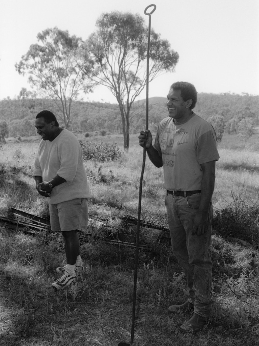 Black and white photos of Uncle Butch and Uncle Kenny standing, grass and trees behind them.