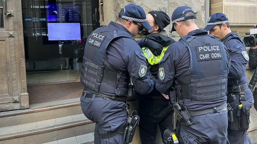 a person is held while police officers place handcuffs on the person