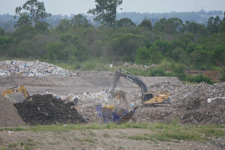 Two heavy loaders move construction waste at a landfill at New Chum, Ipswich