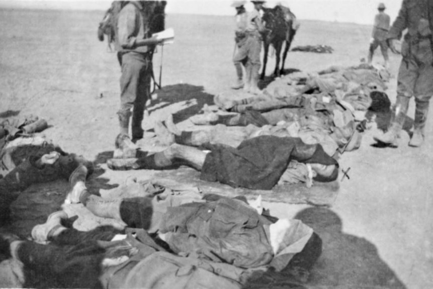 Black and white image of the dead bodies of Australian soldiers killed in the charge on Beersheba lying in a row on the ground.