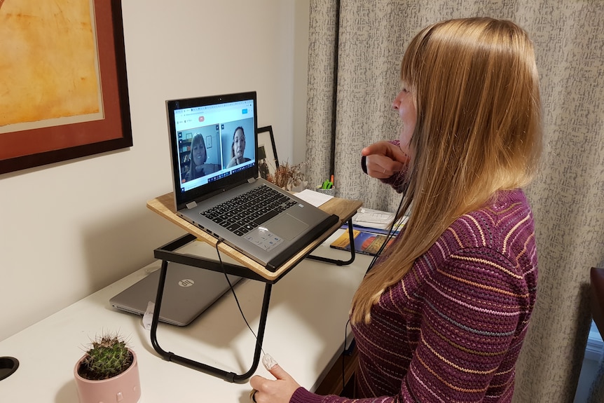 Woman gestures at a laptop screen