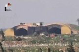 A television still shows the burned and blackened inside of the hangar at the Shayrat airbase.