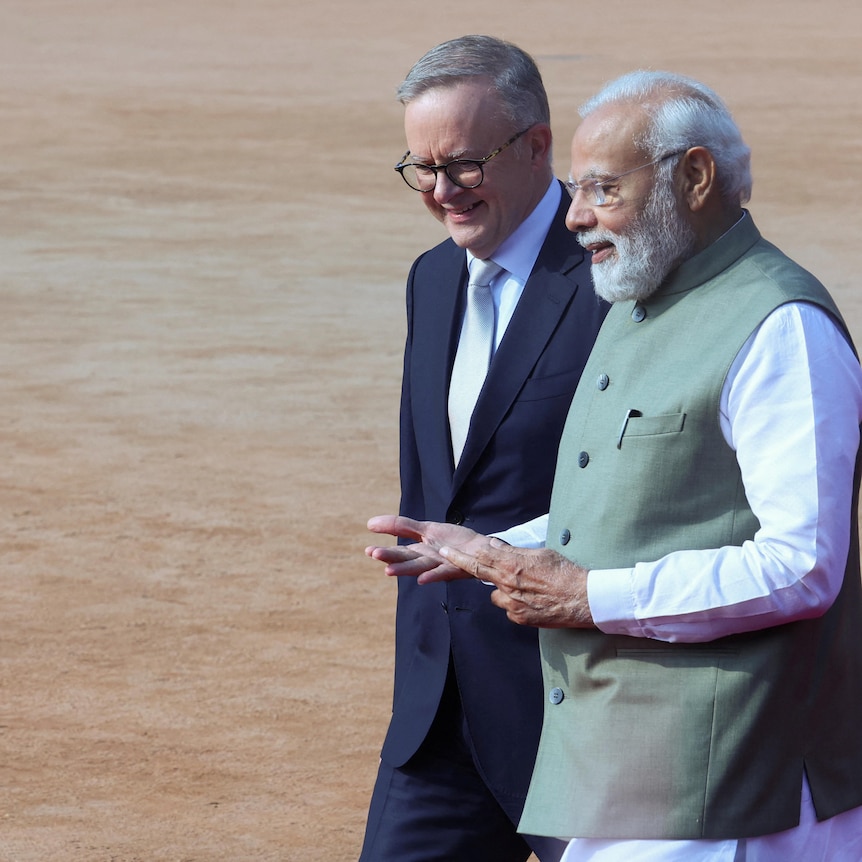 Anthony Albanese and Narendra Modi walk together.