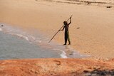 A boy uses a spear to fish at the beach in Maningrida, in the Gulf of Carpentaria.