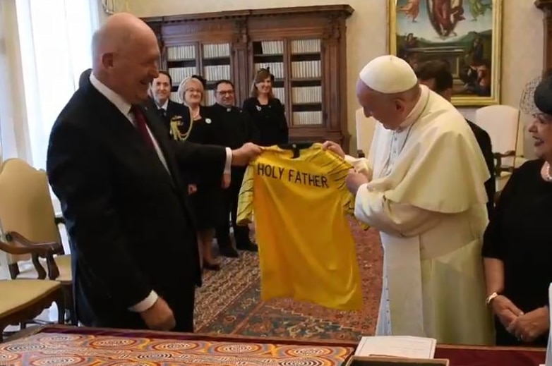 The Governor-General of Australia hands the pope a jersey with the name "Holy Father" emblazoned on the back.