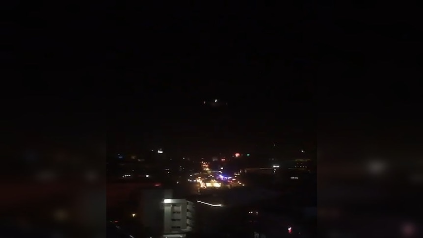 A Turkish jet swoops over a crowded street