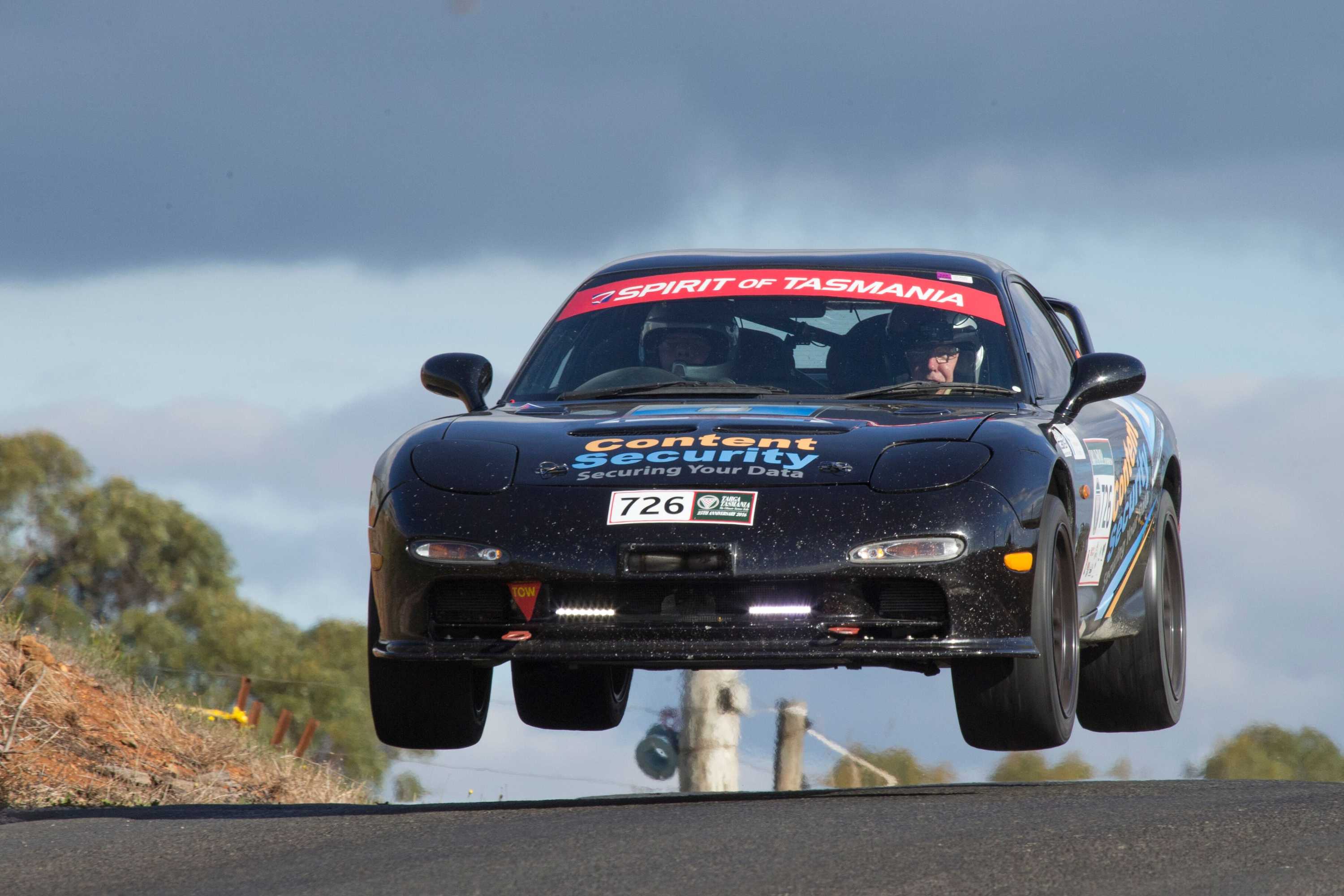 A Targa car in the air on a road hump.