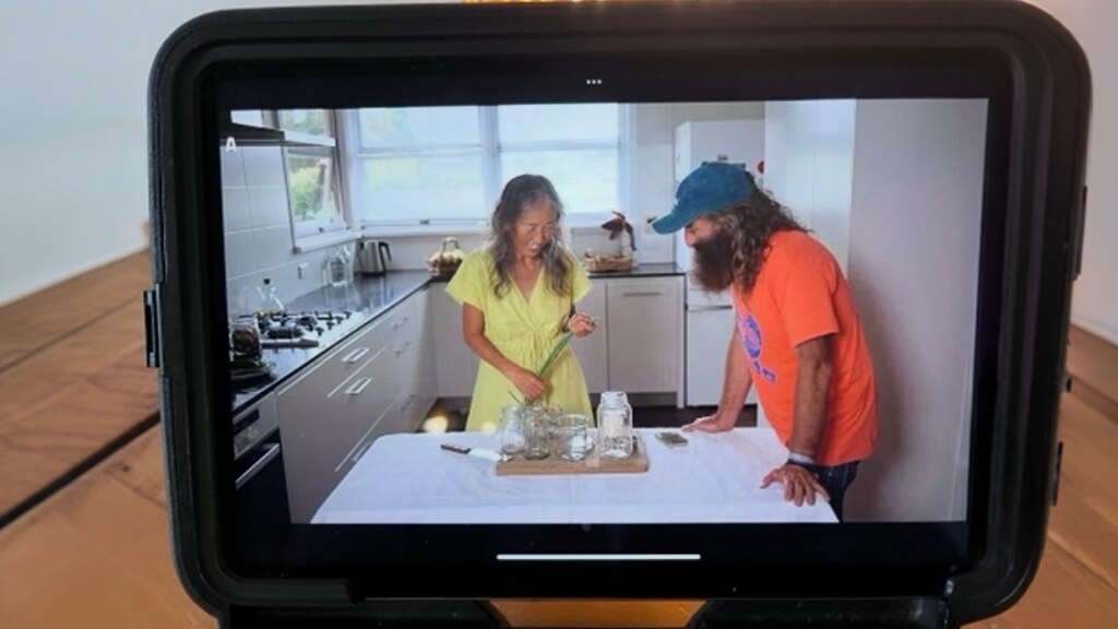 Costa and Ping through a viewfinder of a camera.