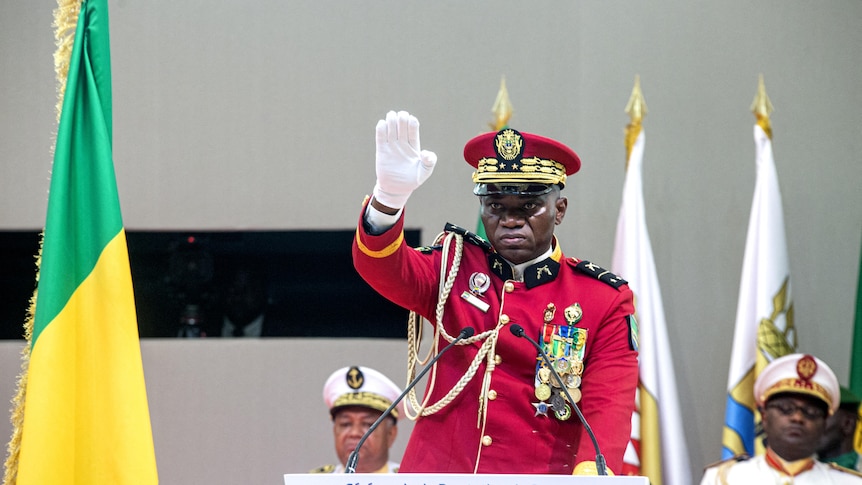 Man in red military uniform salutes hand 
