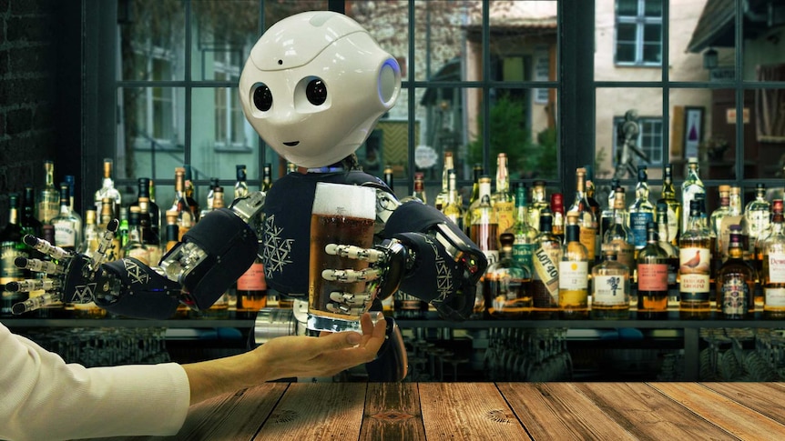 A robot serves a glass of beer from behind a fully-stocked bar.