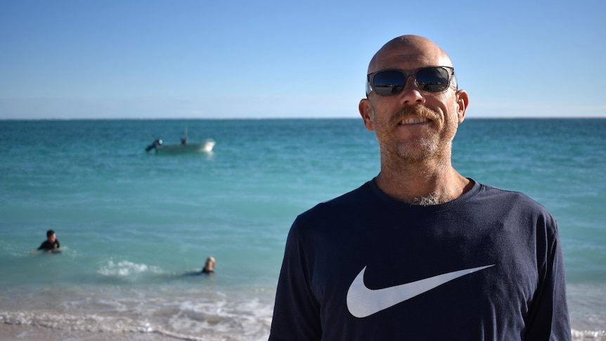 Man wearing sunglasses in front of the ocean