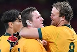 Two Wallabies players hug as they celebrate beating the All Blacks in Brisbane.