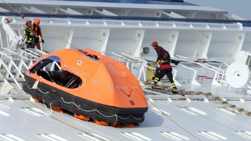 Rescuers work on the side of the Costa Concordia.