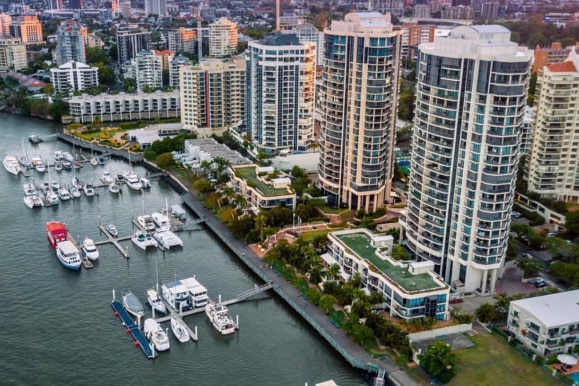 Aerial view of city skyline with marina and boats in foreground