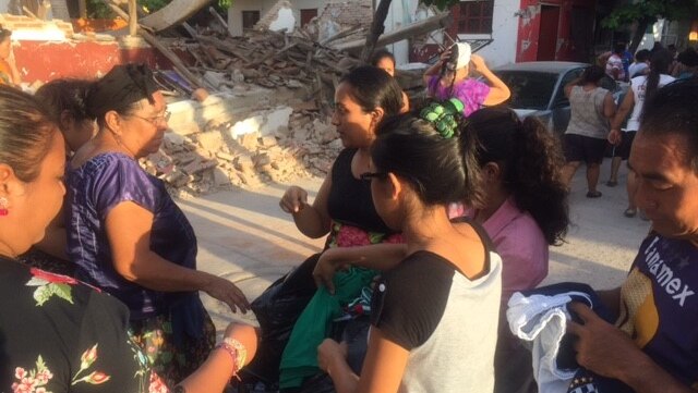 Locals in Juchitan look for clothes in a bag given to them by charity workers.