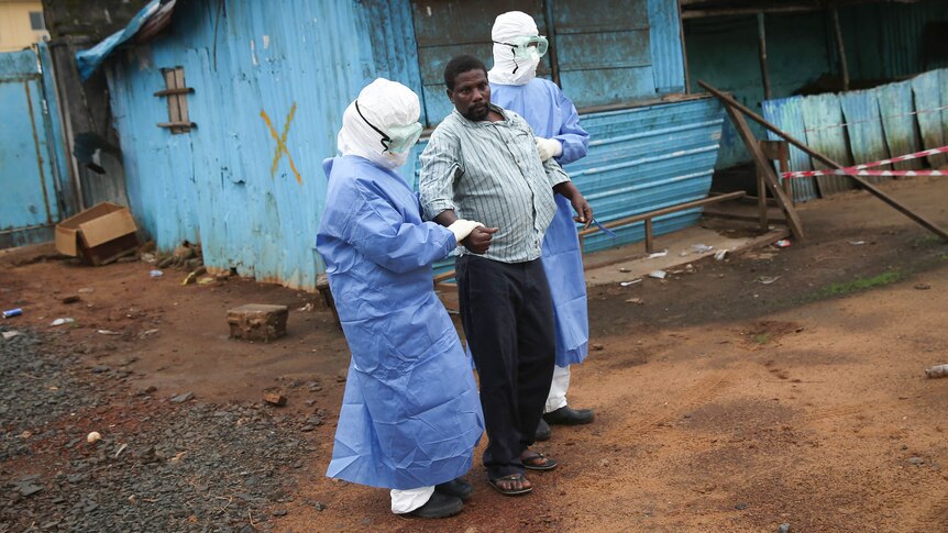 Nurses escort an Ebola survivor