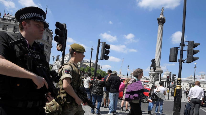 A soldier and a police officer walk past Trafalgar Square during a mobile patrol in central London.