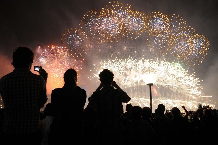 New Year's Eve revellers photograph the midnight fireworks off the Sydney Opera House