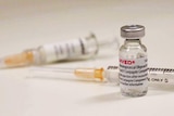 Two syringes and a small vial of vaccine.